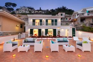 a patio with white furniture in front of a house at Gala Residence Villa Giovanna in Ravello