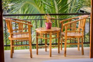 duas cadeiras e uma mesa com um vaso de plantas num alpendre em Jero Griya Ubud em Ubud