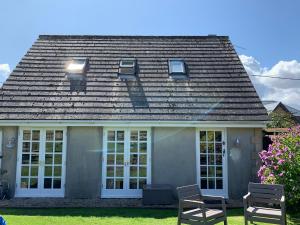 a house with two chairs in front of it at The Bothy in Pewsey