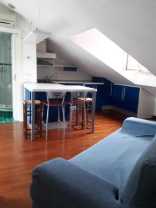 a room with a bed and a table and a kitchen at La Mansardina del Giardinetto in Oderzo