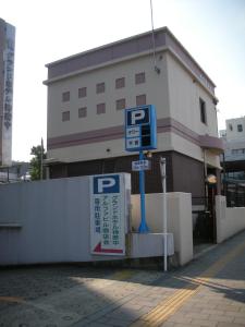 um sinal de estacionamento em frente a um edifício em Grand Hotel Kanachu Hadano em Hadano