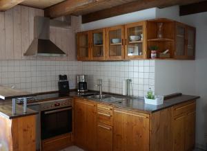 黑倫貝格的住宿－Ferienhaus am Schönbuchrand，厨房配有木制橱柜、水槽和炉灶。