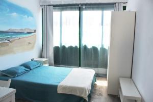 sypialnia z łóżkiem i dużym oknem w obiekcie Apartamento muy cercano a playas y pueblo Puerto del Carmen w Puerto del Carmen
