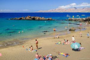 Grupa ludzi na plaży w wodzie w obiekcie Apartamento muy cercano a playas y pueblo Puerto del Carmen w Puerto del Carmen