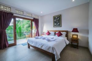 乌布Jero Griya Ubud的一间带大床的卧室和一个阳台