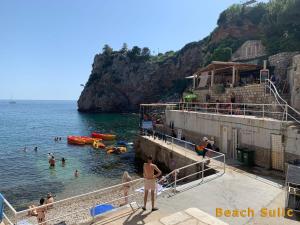 un grupo de personas en el agua en una playa en Rooms Villa Garden, en Dubrovnik