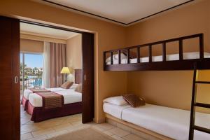 a bedroom with two bunk beds and a balcony at JAZ Mirabel Resort in Sharm El Sheikh