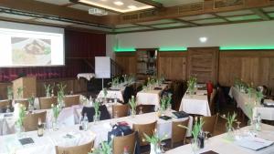 a conference room with white tables and chairs with plants on them at Hotel - Landgasthof Obermaier Zum Vilserwirt in Altfraunhofen