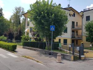 a blue sign in front of a building with a tree at Appartamento Diamantina in Desenzano del Garda