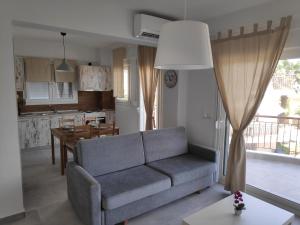 a living room with a couch and a kitchen at Melistalia appartment 1 in Nea Michaniona