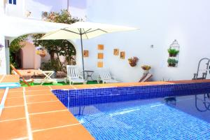 a pool with an umbrella and a swimming pool at Casa dos Tios Estremoz-veiros in Veiros