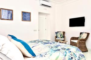 a bedroom with a bed and two chairs at Gema Suites in Positano