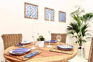 a dining room table with blue and white plates and glasses at Gema Suites in Positano