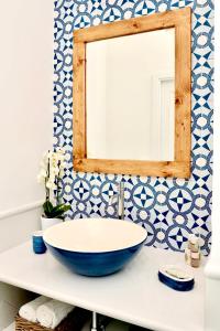 a bathroom with a large bowl sink and a mirror at Gema Suites in Positano