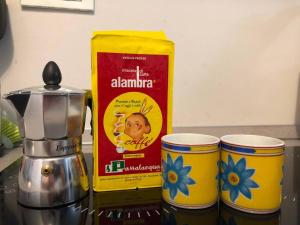a box of alambrica next to two cups on a counter at THE RABBIT HOLE in Milan