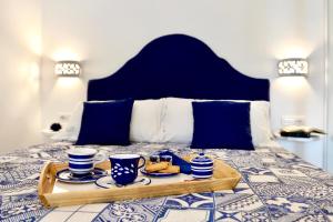 a tray with cups and saucers on a bed at Gema Suites in Positano