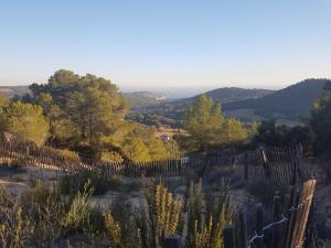 - une vue sur une colline avec une clôture et des arbres dans l'établissement le petit Eden de la Madrague face à la Ciotat, à Saint-Cyr-sur-Mer