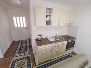 a small kitchen with white cabinets and a sink at Ilidza Nature Home in Sarajevo