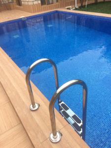 a swimming pool with metal rails next to a swimming pool at Sheki Apartments in Sheki