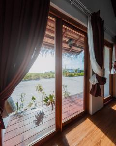 a room with a large window with a view of the water at Club Kaafu Maldives in Dhiffushi