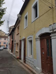 a yellow building with a brown door on a street at Lourdes Guest House in Lourdes