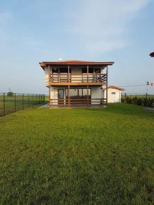 a house with a large yard with a grass field at Hacienda del Mar'a in Vama Veche