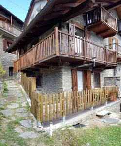 ein Holzzaun vor einem Haus in der Unterkunft Maison Bellevue - locazione turistica breve in Aosta