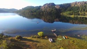 an aerial view of a lake with boats on the shore at Laguna Larga Lodge in Parque Nacional Los Alerces