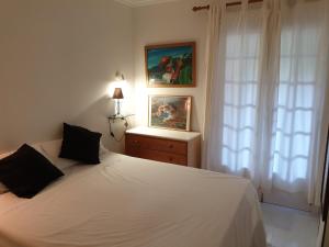 une chambre avec un lit blanc et une fenêtre dans l'établissement JAVEA - La Isla, à Jávea 94 autres photos