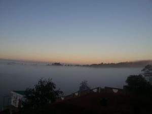 a misty sunrise with the sun rising in the horizon at Ecole Lodge Antananarivo in Mahitsy
