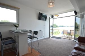 a living room with a couch and a table and chairs at Premium Lake Lodges in Chichester