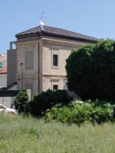 ein altes Haus mit einem Baum davor in der Unterkunft Dimora Dei Cento in Pescara