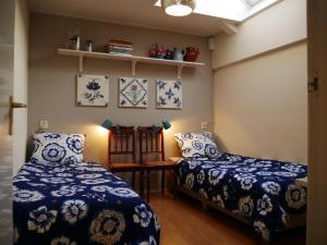2 Betten in einem Zimmer mit blauen und weißen Decken in der Unterkunft d'AldeSkoalle in Molkwerum