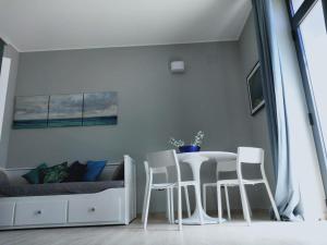 ein Wohnzimmer mit einem Tisch und weißen Stühlen in der Unterkunft Dimora Dei Cento in Pescara
