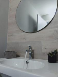 ein Bad mit einem Waschbecken und einem Spiegel in der Unterkunft Dimora Dei Cento in Pescara