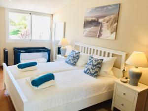 1 dormitorio con 2 camas y almohadas azules y blancas en Villa BEACH&OCEAN, en Son Serra de Marina