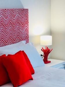 Un dormitorio con una cama con almohadas rojas y una lámpara. en Sorrento ResArt Suite, en Sorrento