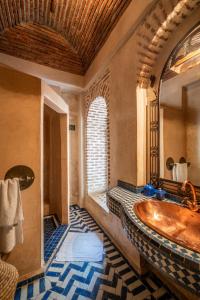 a bathroom with a large tub and a window at Riad Adilah Marrakech - by EMERALD STAY in Marrakesh