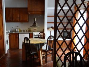 a kitchen with a table and chairs in a kitchen at Casa São João in Peniche