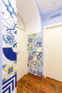 ナポリにあるAristovascioのカラフルなタイル張りの壁とドアが特徴の客室です。