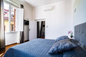 una camera con un letto blu e una finestra di Live Florence Guest House a Firenze