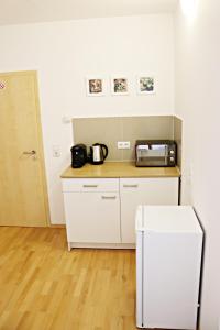a kitchen with a counter with a microwave and a refrigerator at Dornfelder in Hanhofen