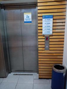 un ascensor de metal con dos letreros. en Hotel Terra Valdivia, en Valdivia