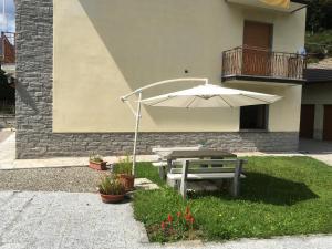 a picnic table and an umbrella in a yard at Casa Ezio in Malesco +2 photos