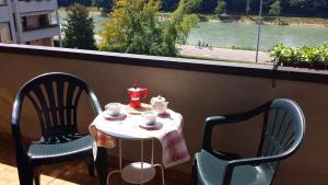 a table and two chairs on a balcony with a view of a river at Verona Amazing River View in Verona