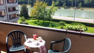 a table and chairs on a balcony with a view of a river at Verona Amazing River View in Verona