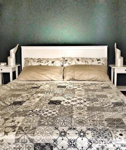 ein Schlafzimmer mit einem großen Bett mit zwei Tischen in der Unterkunft Noi Due Guest House - Fubine Monferrato in Fubine