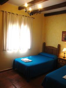 a bedroom with two beds and a window at Casa Rural La Chumbera in Órgiva