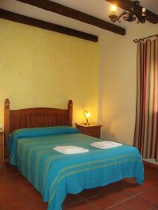 a bedroom with a bed with a blue bedspread at Casa Rural La Chumbera in Órgiva