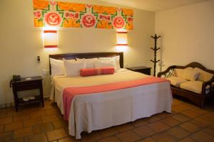 a bedroom with a large bed and a couch at Parador del Dominico in Oaxaca City